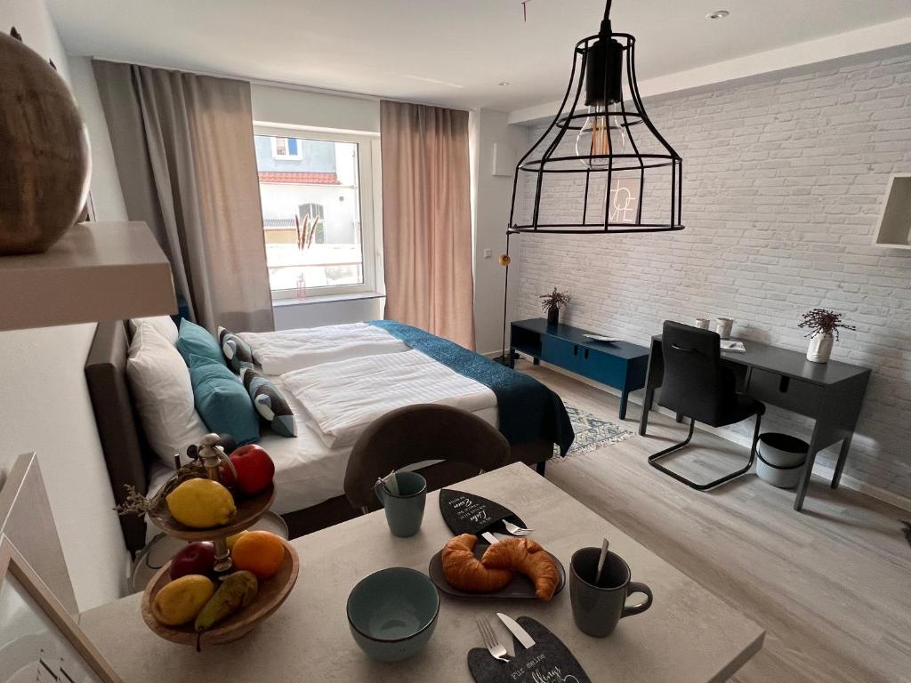 汉诺威SOFI-LIVING-APARTMENTS的一间卧室配有一张床和一张带水果的桌子