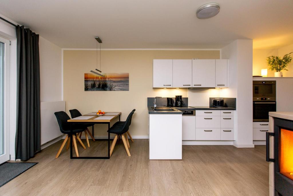 普劳西Hafendorf Haus 7_ Apartment 4的厨房以及带桌椅的用餐室。