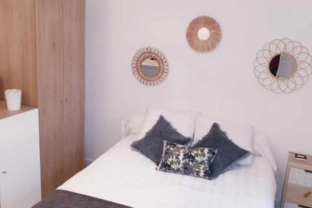 拉罗什波赛Bienvenue au 8 Bis的卧室配有白色的床和枕头。