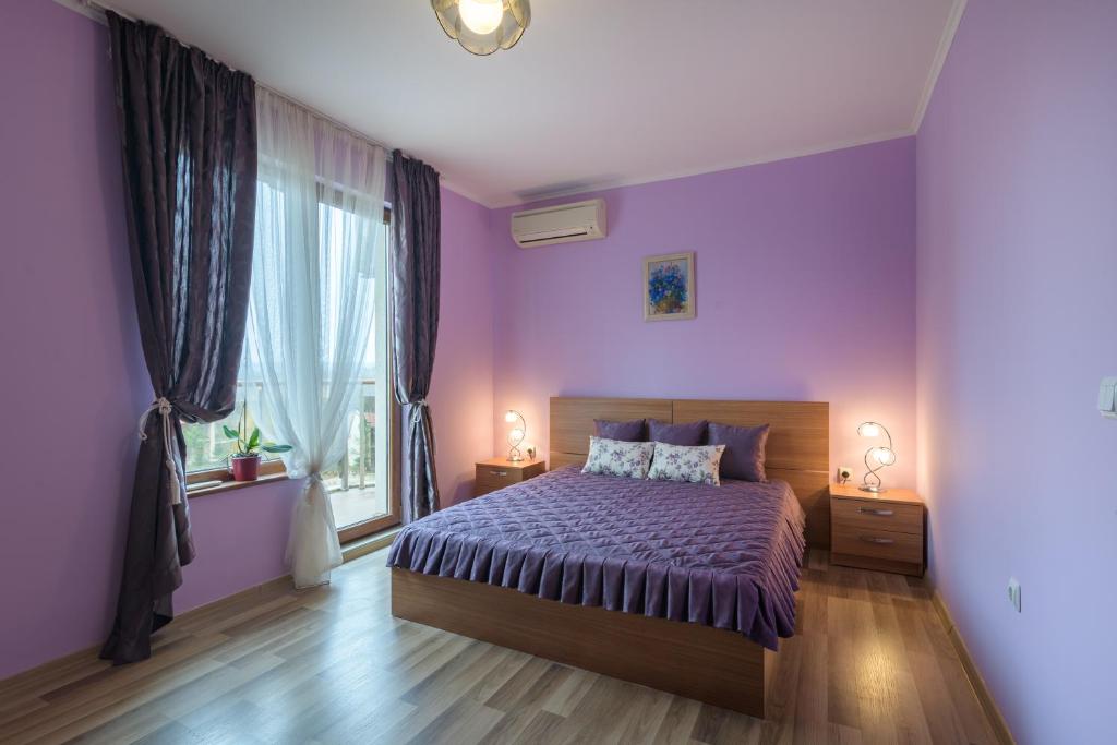 希科尔皮诺夫西Infinity View Shkorpilovci的紫色卧室设有一张床和一个窗户