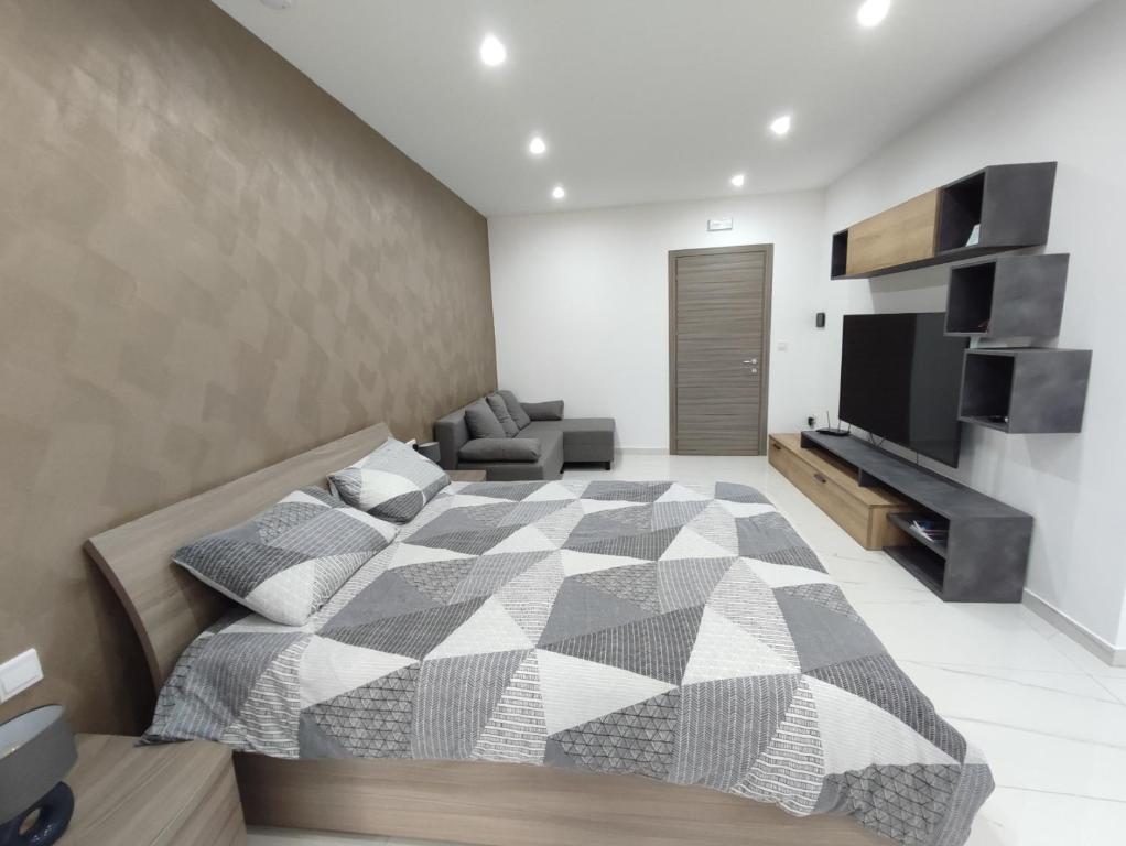 马尔萨斯卡拉Il-Girna的一间卧室配有一张床、一张沙发和一台电视