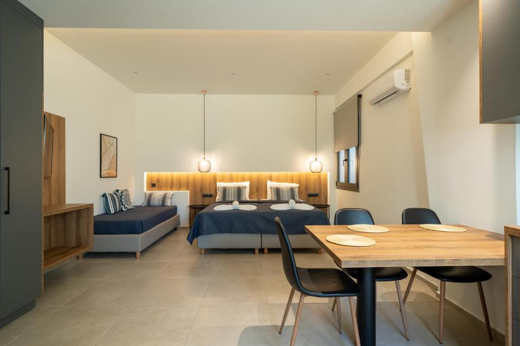 斯塔里斯Esperos Studios and Apartments, #2的酒店客房带两张床和一张桌子以及椅子。