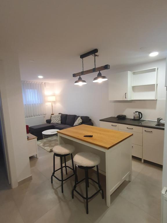 萨格勒布Cosy 35m2 appartment的厨房以及带桌子和凳子的客厅。