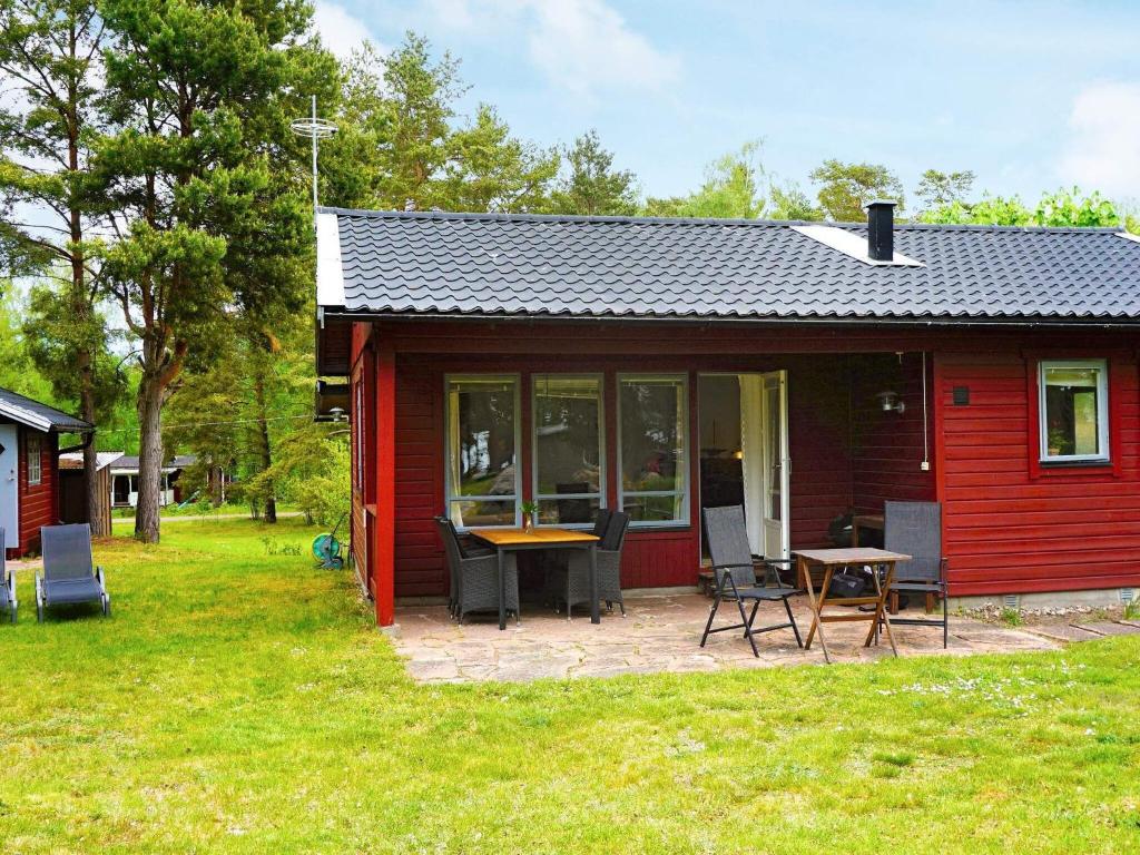 门斯特罗斯Holiday home Mönsterås VII的院子里的红色小屋配有桌椅
