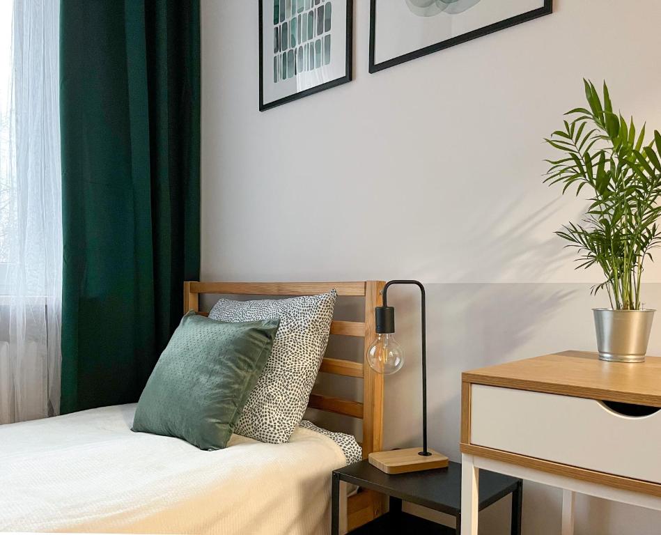 华沙Shape&Color premium Hostel的一间卧室配有一张带绿帘的床