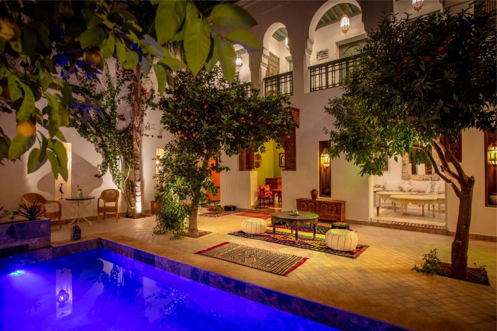 马拉喀什Riad les remparts de la kasbah的树木繁茂的屋子中间的游泳池