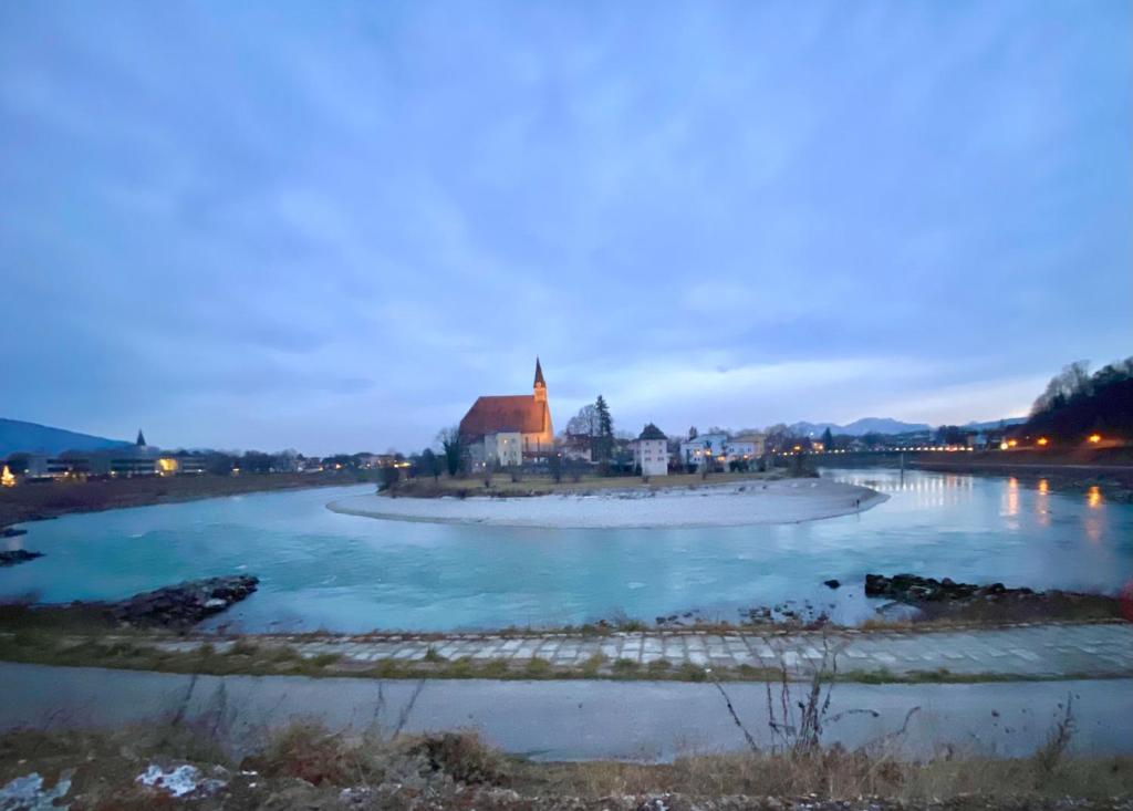 劳芬Ferienwohnung an der idyllischen Salzachschleife Nähe Salzburg的享有河流和远处教堂的景色