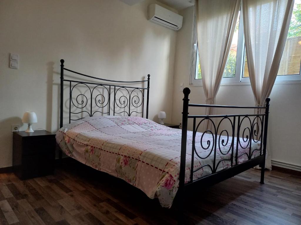 雅典Modern and Cosy Apartment的一间设有黑床的卧室,位于带两个窗户的房间