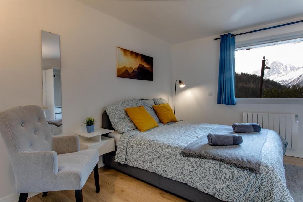 里雾诗Chalet Grand Balcon的卧室配有床、椅子和窗户。