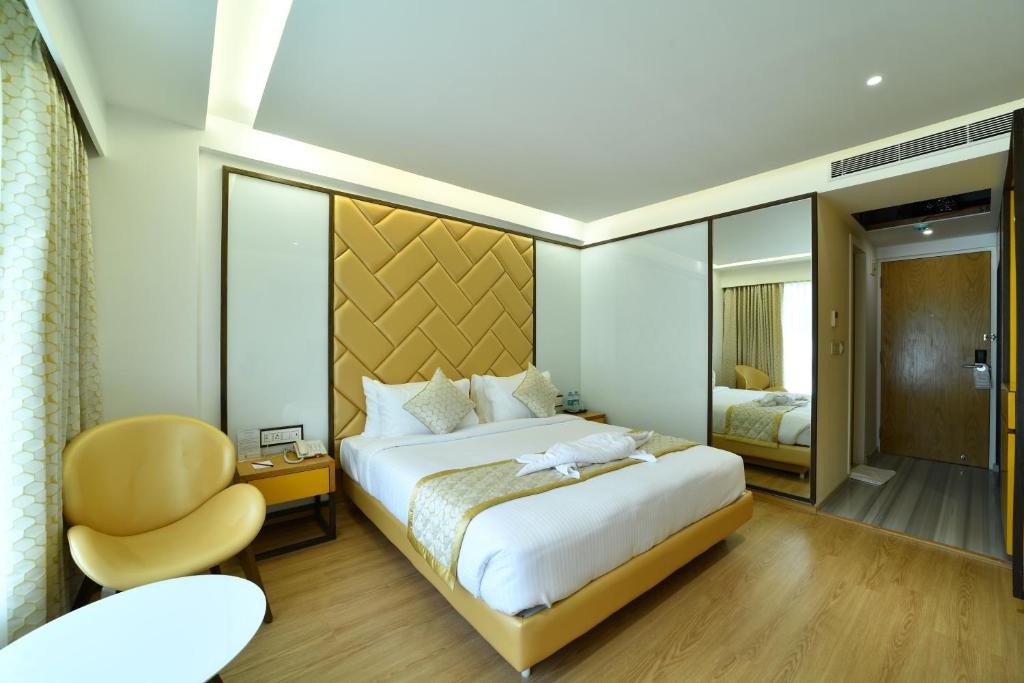 班加罗尔The President Hotel, kumarapark的一间卧室配有一张大床和一把椅子