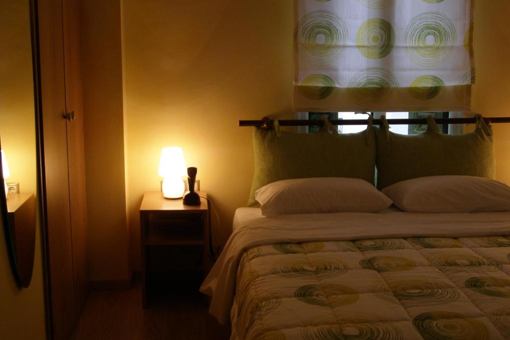 卡斯托里亚Room "honeybee" in a neoclassical house的一间卧室配有一张带灯和窗户的床
