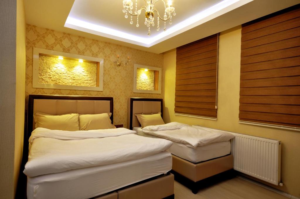 卡尔斯卡尔斯康纳克酒店的带吊灯的客房内的两张单人床