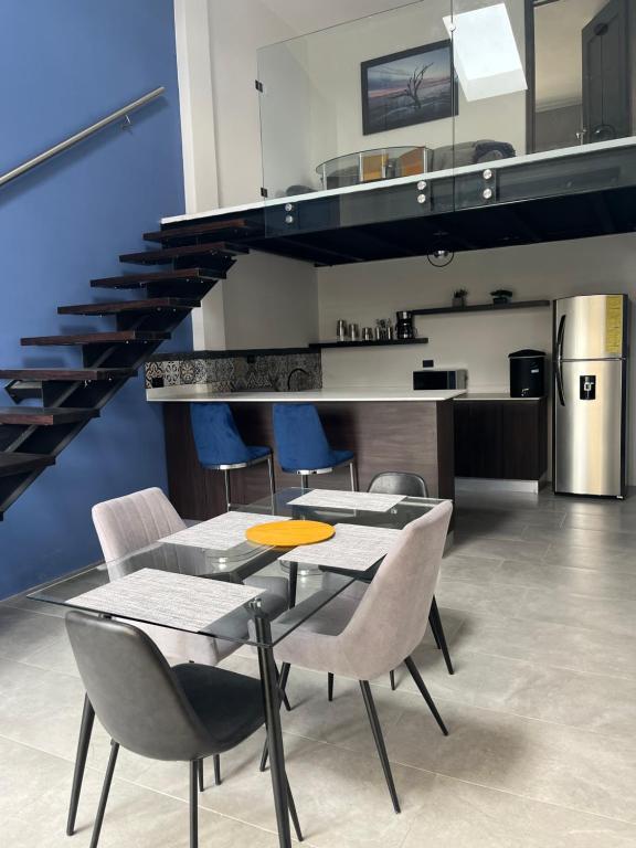 克萨尔特南戈Apartamento en Condominio Privado的一间带桌椅和楼梯的用餐室