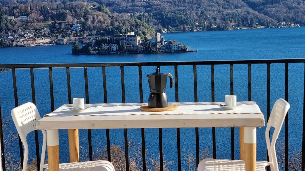 佩拉Luckylake的阳台上配有带咖啡壶的桌子和两把椅子