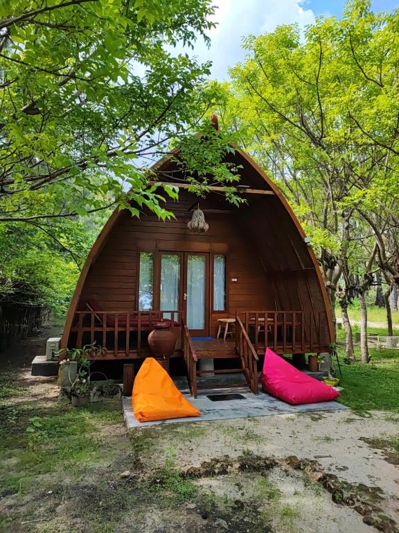 BaingWajonata Sumba的大型木制小屋,配有桌子和色彩缤纷的帐篷