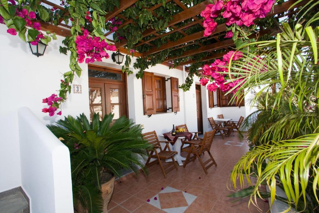 林都斯林都斯阿纳斯塔西娅一室公寓的庭院配有桌椅和粉红色的鲜花