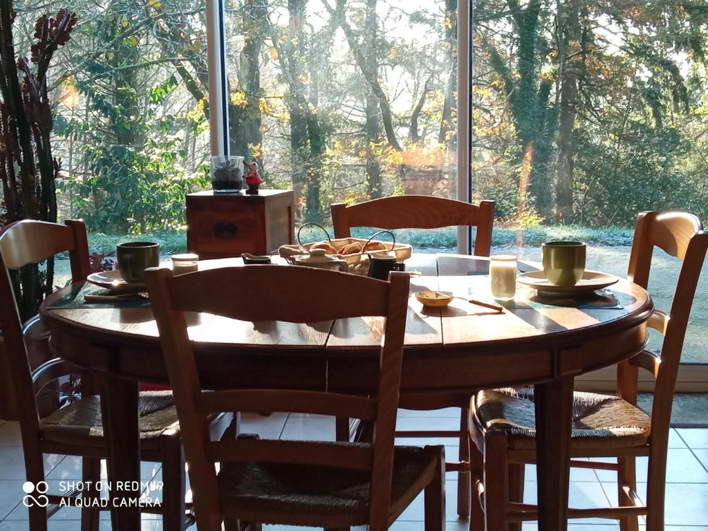 莱瑟佩瑟Les Trois Geais的餐桌、椅子和大窗户