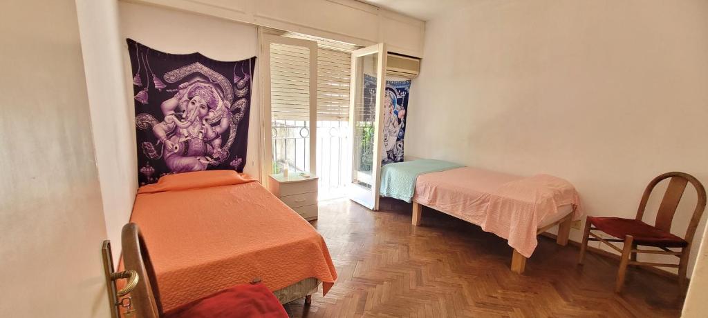 罗萨里奥Habitaciones en el centro de Rosario的小房间设有两张床和窗户