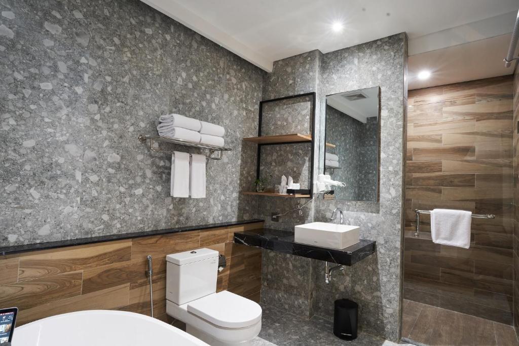 打横Cordela Suites Tasikmalaya的一间带卫生间、水槽和镜子的浴室