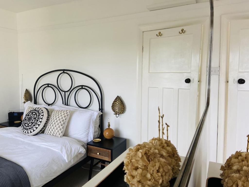 绍斯沃尔德Cottage Number 5 in Southwold - Charming cottage gardens的一间卧室配有一张白色的床和黑色床头板