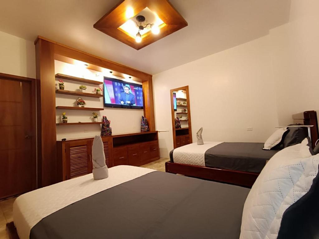 阿约拉港El Arco de Darwin的一间卧室配有两张床和一台平面电视