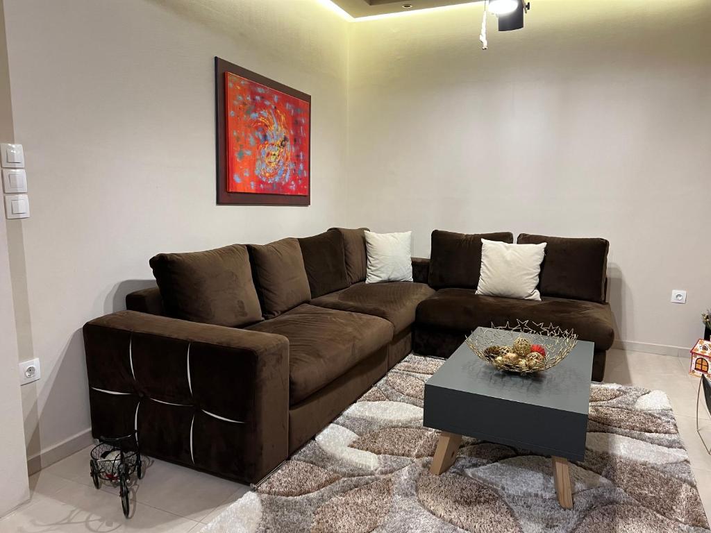 特里卡拉Petite Luxury Urban House的客厅配有棕色沙发和桌子