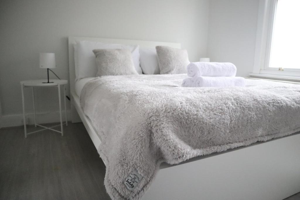 South NorwoodTwelve Thirty Serviced Apartments - 2 Croydon的白色卧室,配有白色的床和泰迪熊