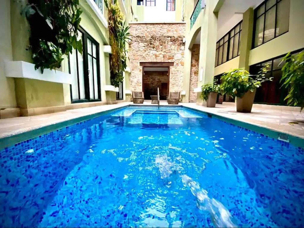 巴拿马城AmazINN Places Casco Viejo unique Desing and Pool VIII的大楼里的一个大型蓝色游泳池