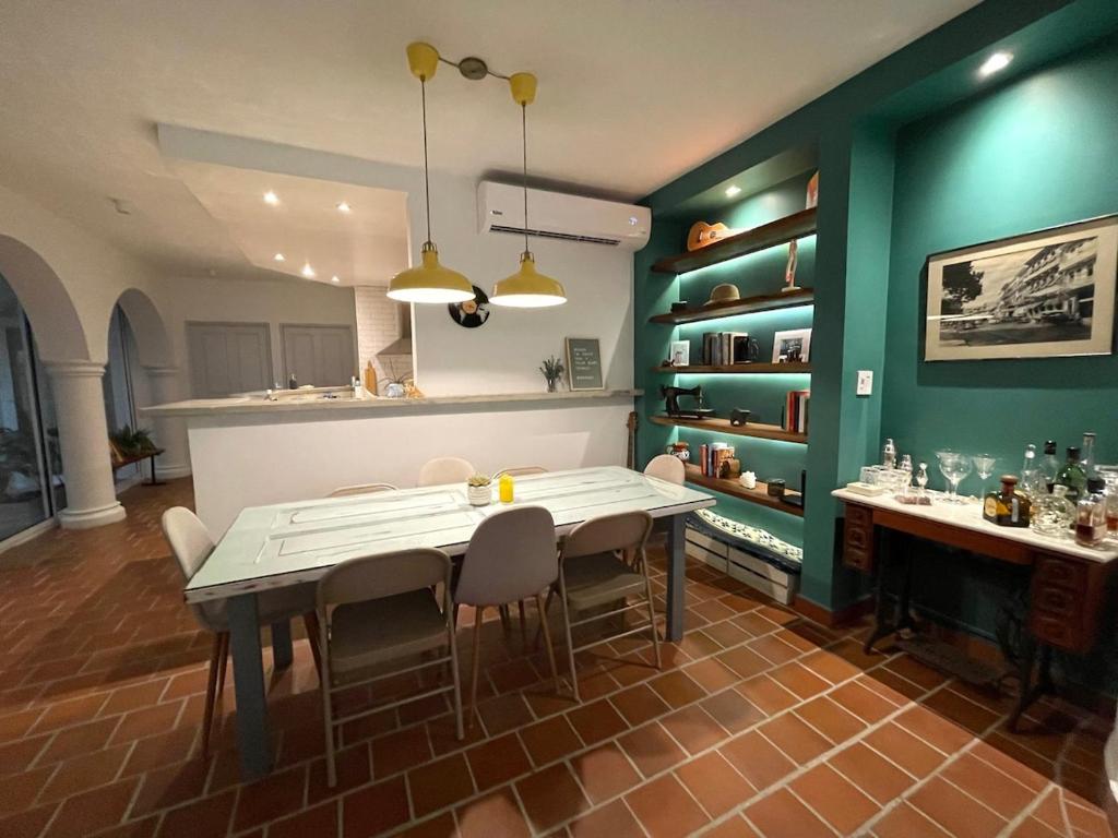 巴拿马城AmazINN Places Casco Viejo Casa Espanola的厨房配有桌椅和绿色的墙壁