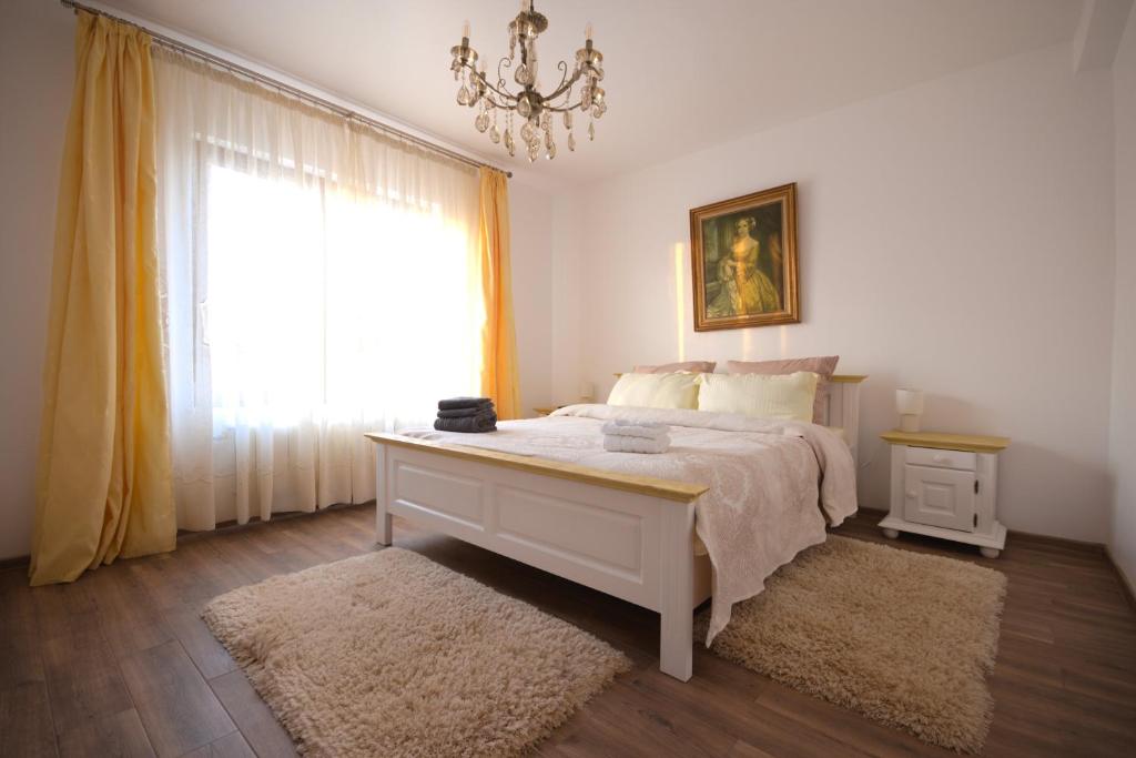 雅西casa Flav的一间卧室配有一张带吊灯和窗户的床。