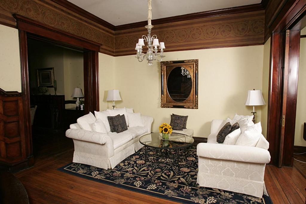奥尔巴尼摩根州议院酒店的客厅配有2把白色椅子和桌子