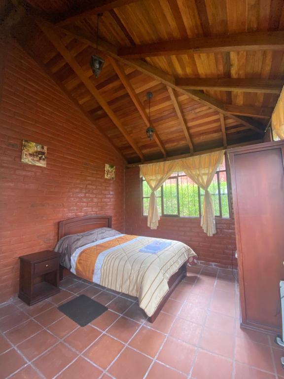 巴尼奥斯Hospedaje Pondoa - Baños de Agua的卧室配有砖墙内的床铺