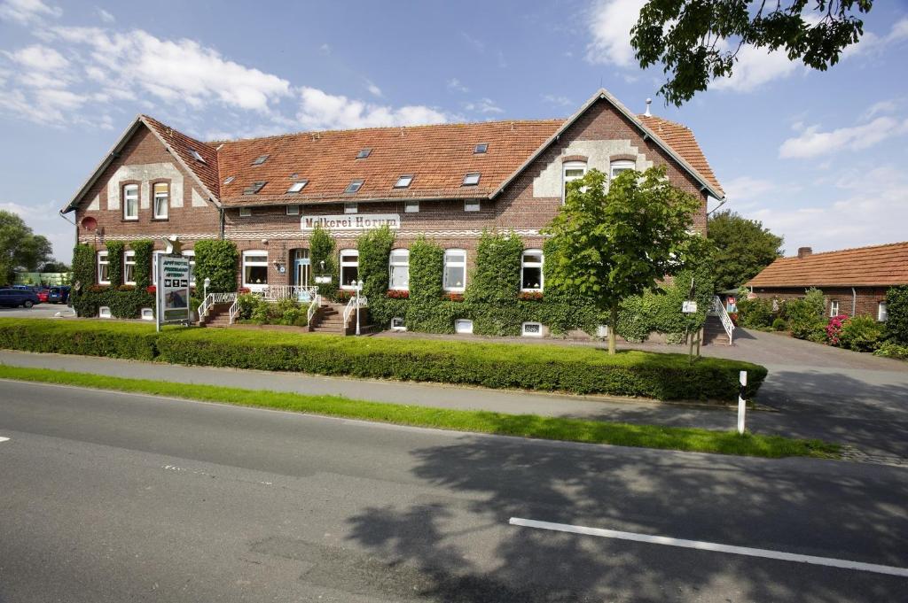 旺格兰Frieslandstern - Ferienhof und Hotel的街道边的大砖房