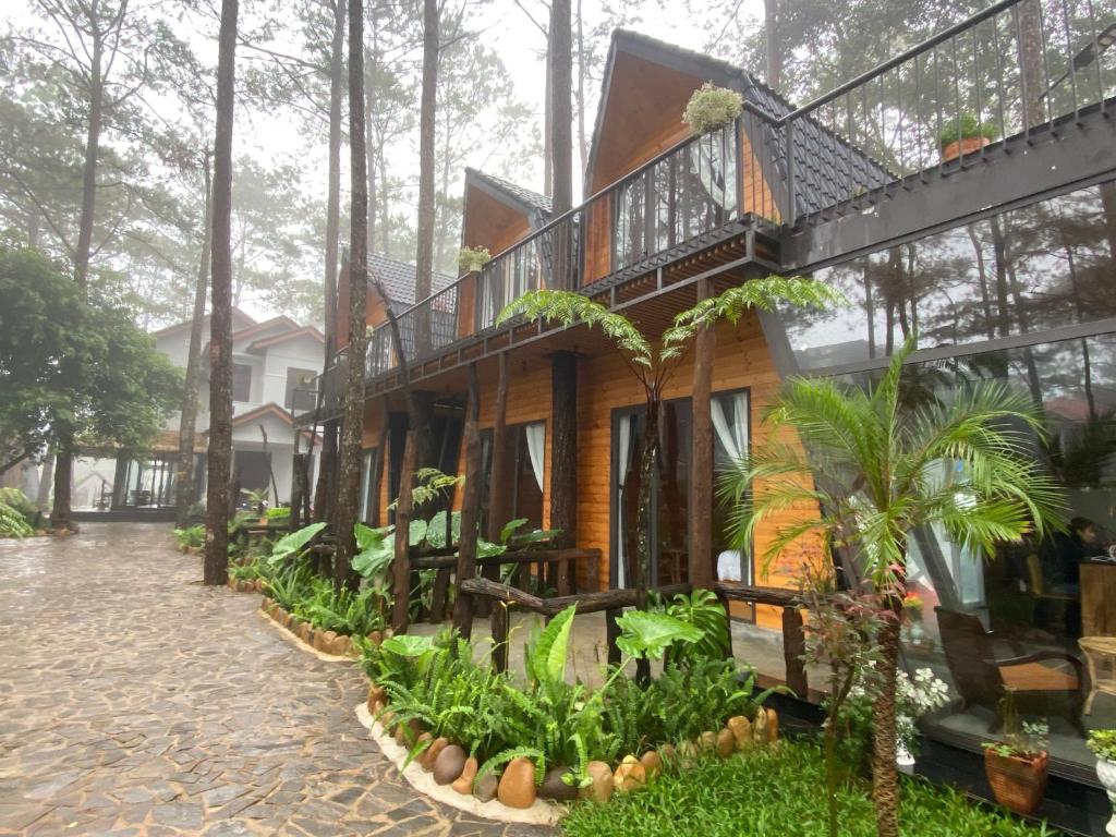 Kon Von KlaT'MĂNG ĐEENG HOMESTAY的树林中的房屋 - 带阳台