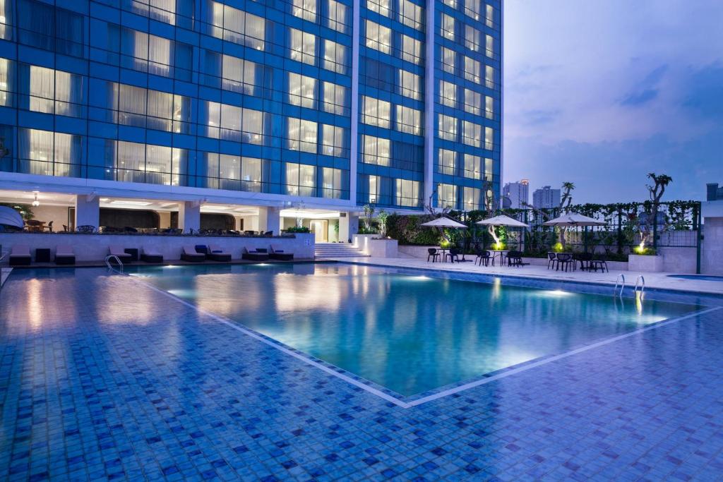 万隆万隆皇冠假日酒店的大楼前的大型游泳池