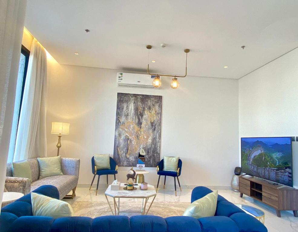 利雅德Spacious new 2 bedroom Apt-in amazing location B6的客厅配有蓝色的沙发和电视