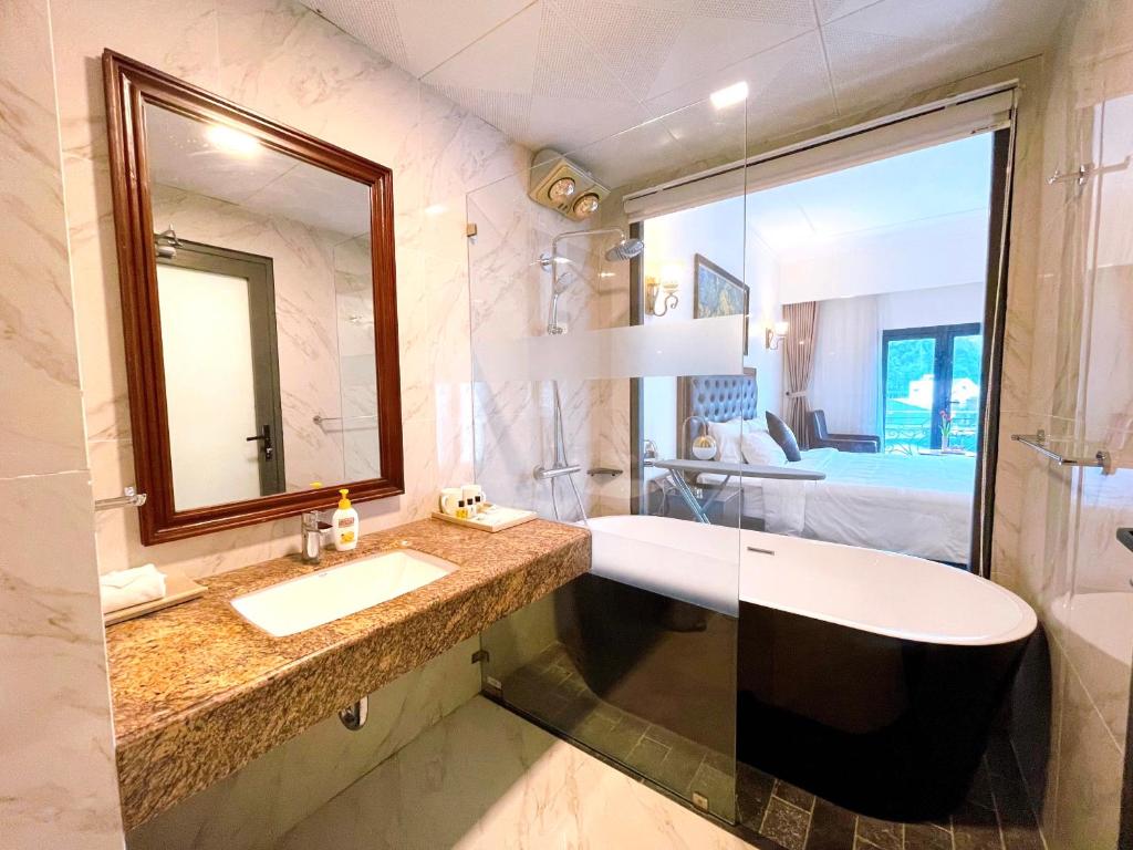 河江Phoenix Hotel Hà Giang的一间带水槽和镜子的浴室以及一张床