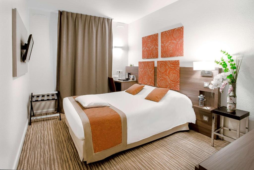 尚贝里凯拉迪尚贝里中心住宿酒店的酒店客房设有一张大床和一张书桌。