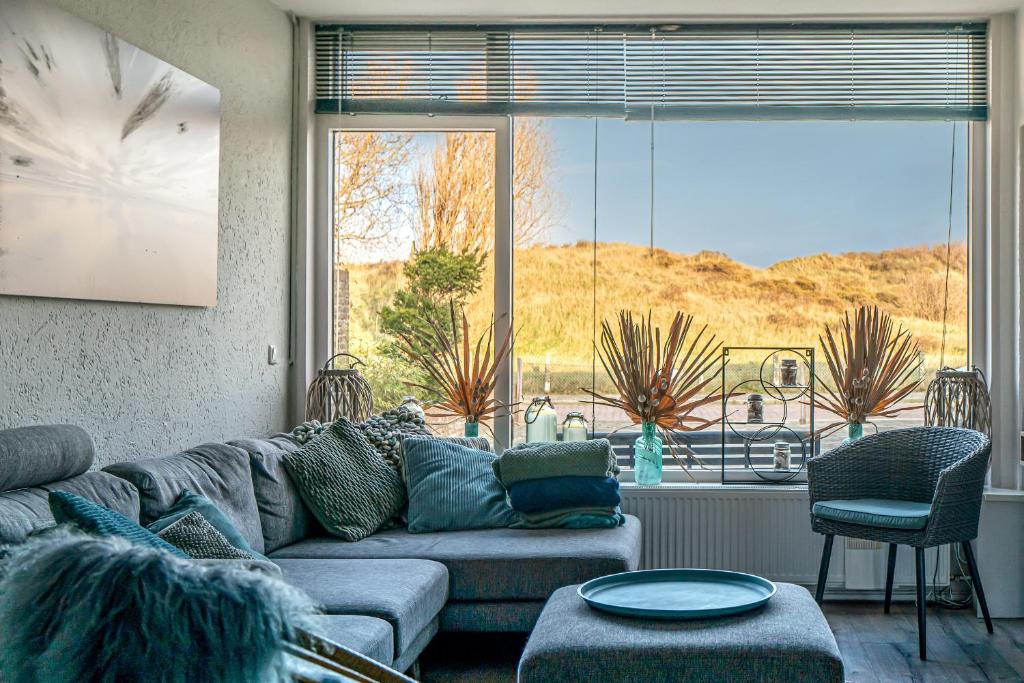 滨海韦克Alibi aan Zee的带沙发和大窗户的客厅