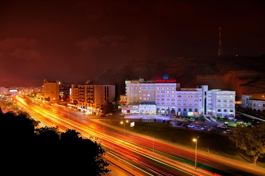 马斯喀特HAFFA HOUSE HOTEL的夜夜亮的城市,建筑物和街道灯