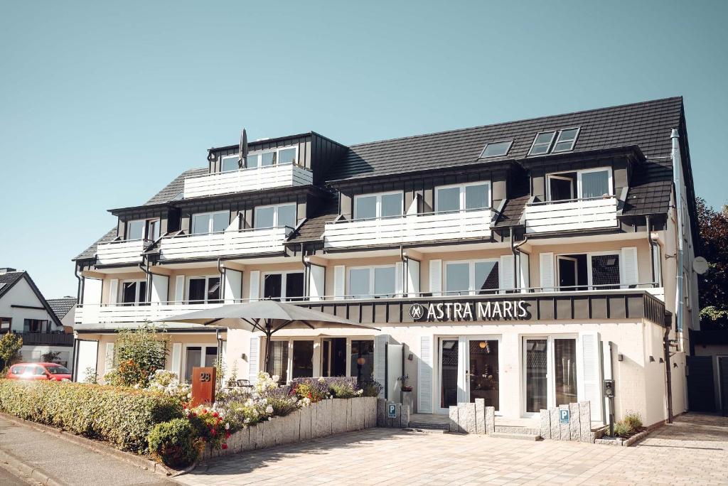 比苏姆Hotel Astra Maris的一座白色的大建筑,上面有标志