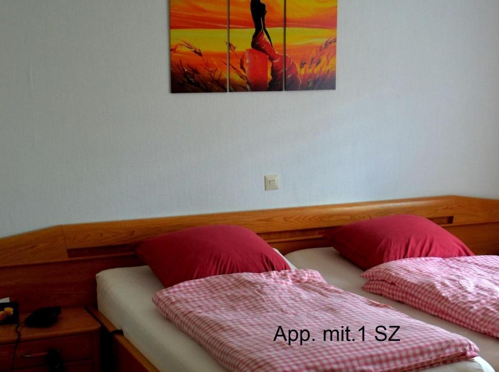 弗兰克瑙Frankenau Fewo Kellerwald的一间卧室设有两张床,墙上挂着一幅画