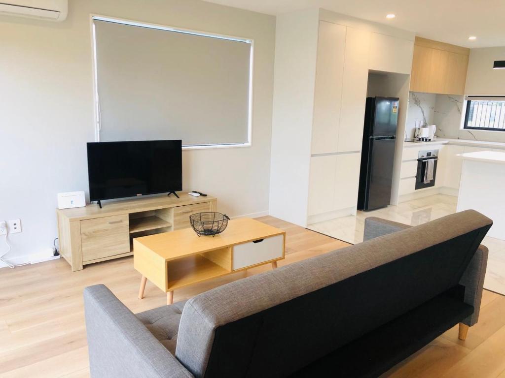 奥克兰Modern & Luxurious Home 2的客厅配有沙发和桌子