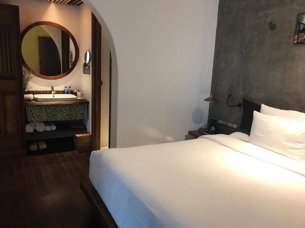 头顿Nancy Grand Strip Villa Imperial 1的卧室配有白色的床和镜子