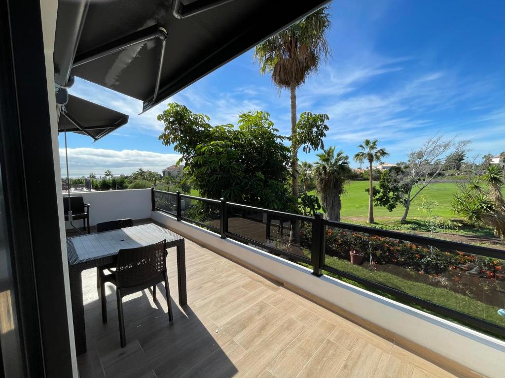 圣米格尔德阿沃纳Residencial Bitacora的阳台配有桌子,享有高尔夫球场的景致。