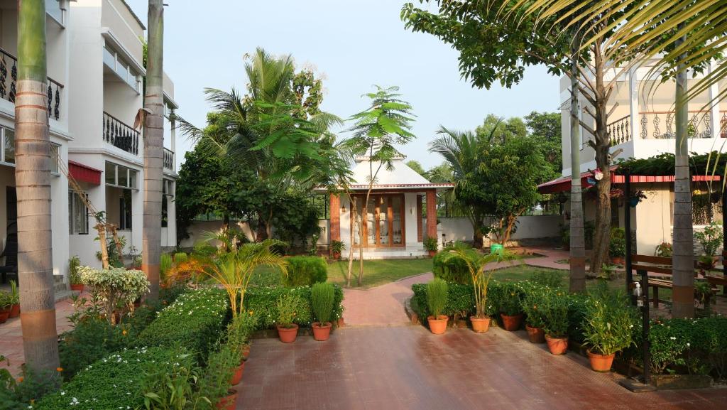 博尔普尔Upasana Eco Resort的一座种有植物和树木的建筑的庭院