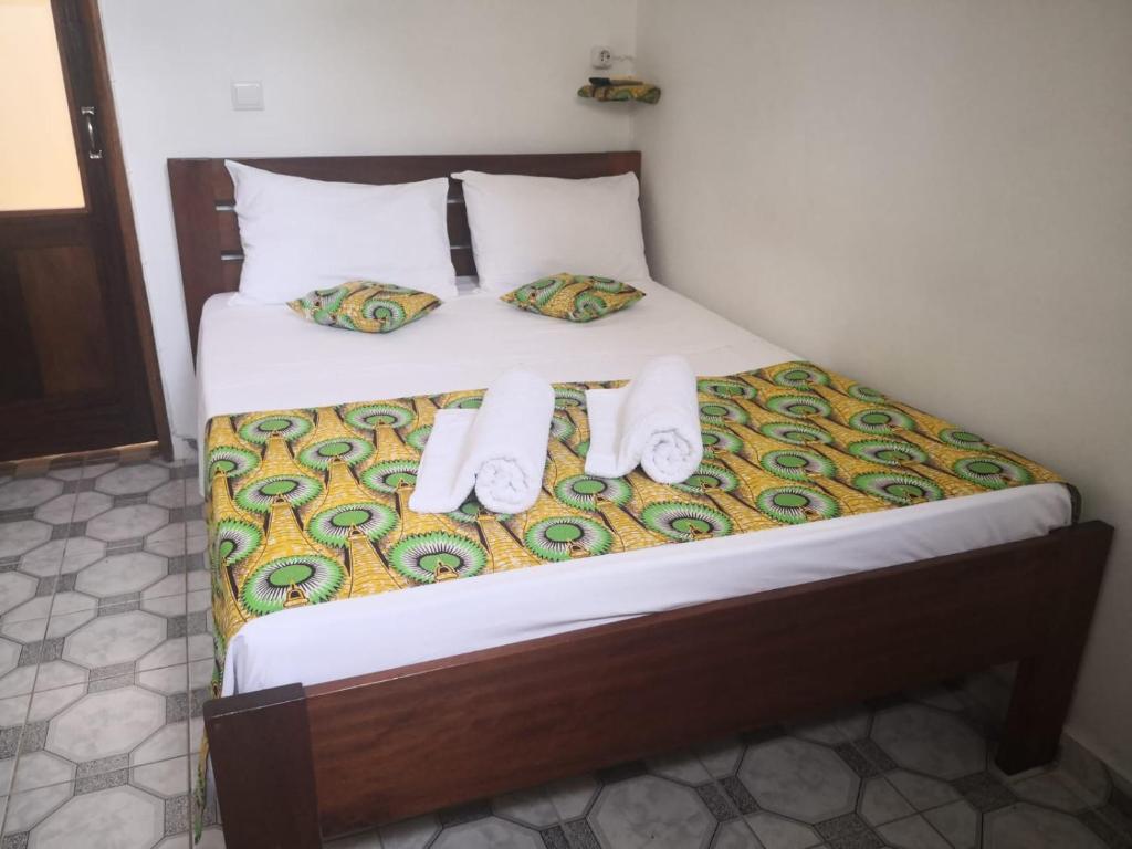 圣多美Micaval Residential的一张带两条毛巾和两个枕头的床
