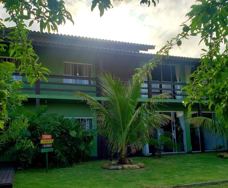皮涅拉Morada Flores de Alaíde - Pinheira的前面有棕榈树的建筑