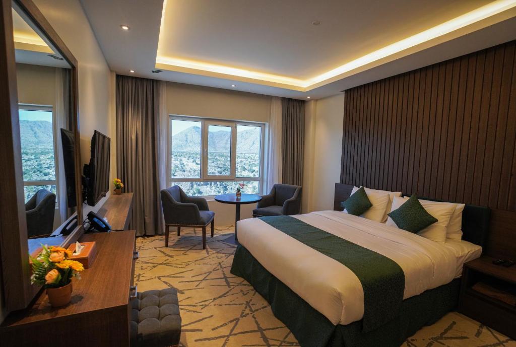 Jabal Al AkhdarGreen View Hotel, Jabal Akhdar的酒店客房,配有一张床、一张桌子和椅子