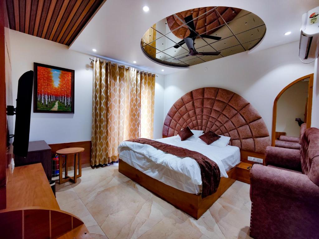 罗塔克Hotel Joylife- Chottu Ram Chowk Rohtak Haryana的酒店客房设有一张大床和一张沙发。